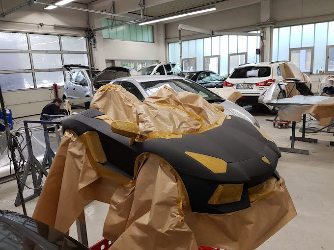 Team von S.G. Autolackierungen bei der gemeinsamen Arbeit an einem Fahrzeug